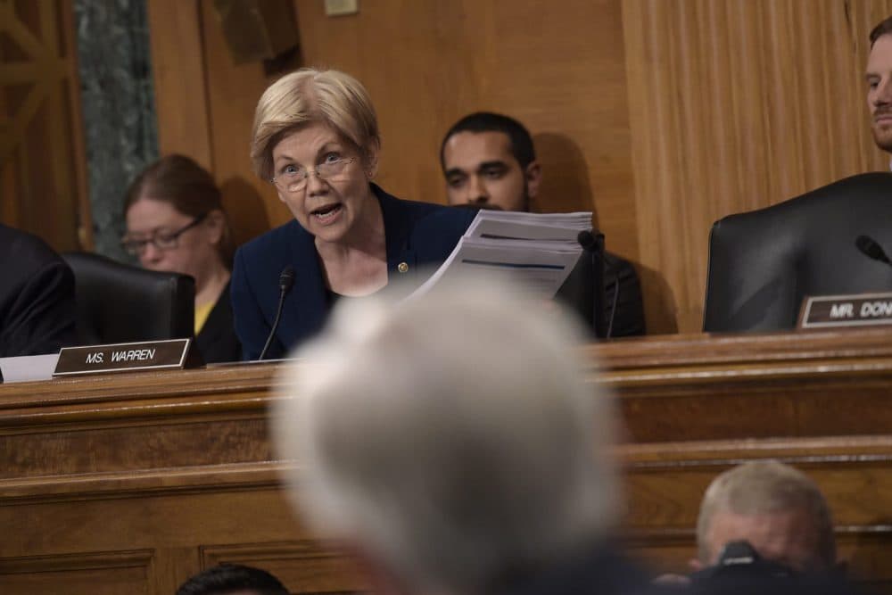 In this file photo, Senate Banking Committee member Elizabeth Warren holds up transcripts of earnings calls as she questions Wells Fargo CEO John Stumpf on Capitol Hill. (Susan Walsh/AP)