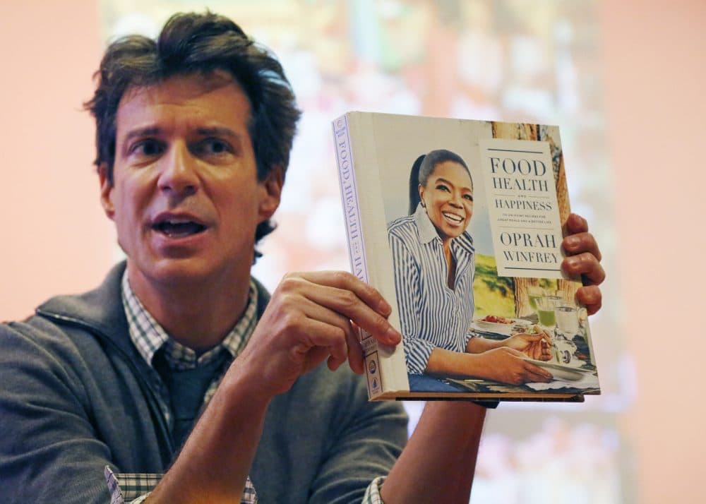 O Magazine creative director Adam Glassman displays a copy of Oprah Winfrey's &quot;Food Health and Happiness.&quot; (Kathy Willens/AP)