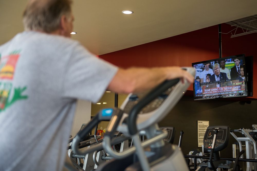 A man watches election coverage broadcast as he works out at a fitness training facility in March 2016 in Conway, Ark. (Michael B. Thomas/AFP/Getty Images)