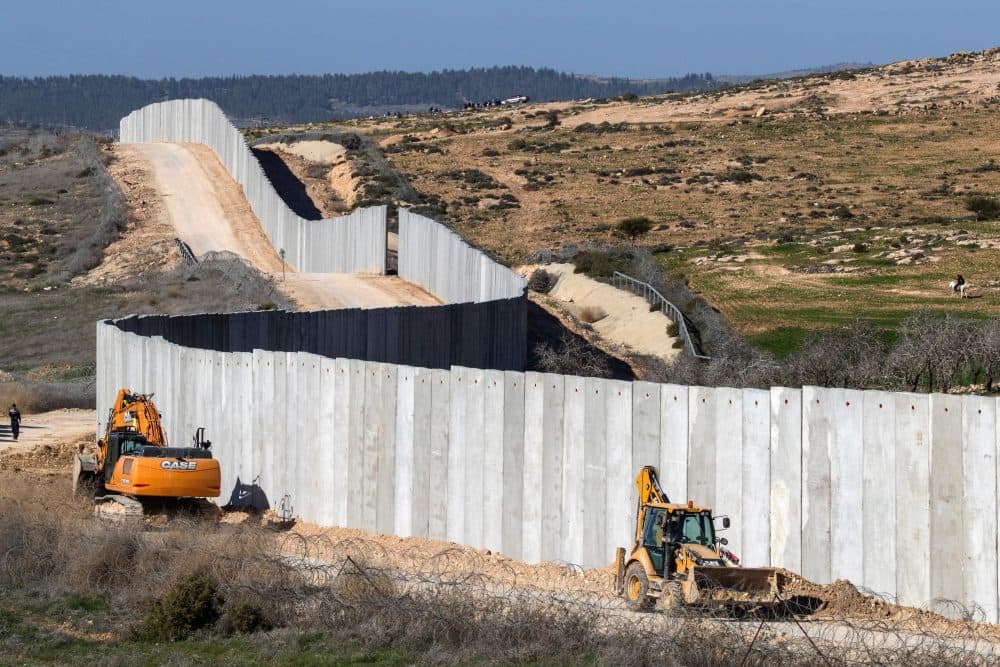 A picture taken near the southern kibbutz of Lahav on Feb. 7, 2017, shows workers building a new section of the controversial Israeli separation wall dividing Israel from the West Bank. (Jack Guez/AFP/Getty Images)