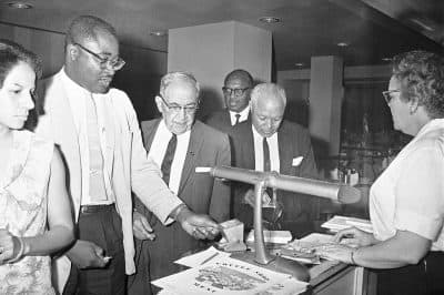 While Kenneth Guscott, president of the Boston NAACP chapter, reaches for a toothpick, Rev. R.L.T. Smith of Jackson reaches into wallet to pay coffee shop bill for the group of blacks, admitted for first time at a downtown Jackson, Miss., hotel in 1964. (Jim Bourdier/AP)