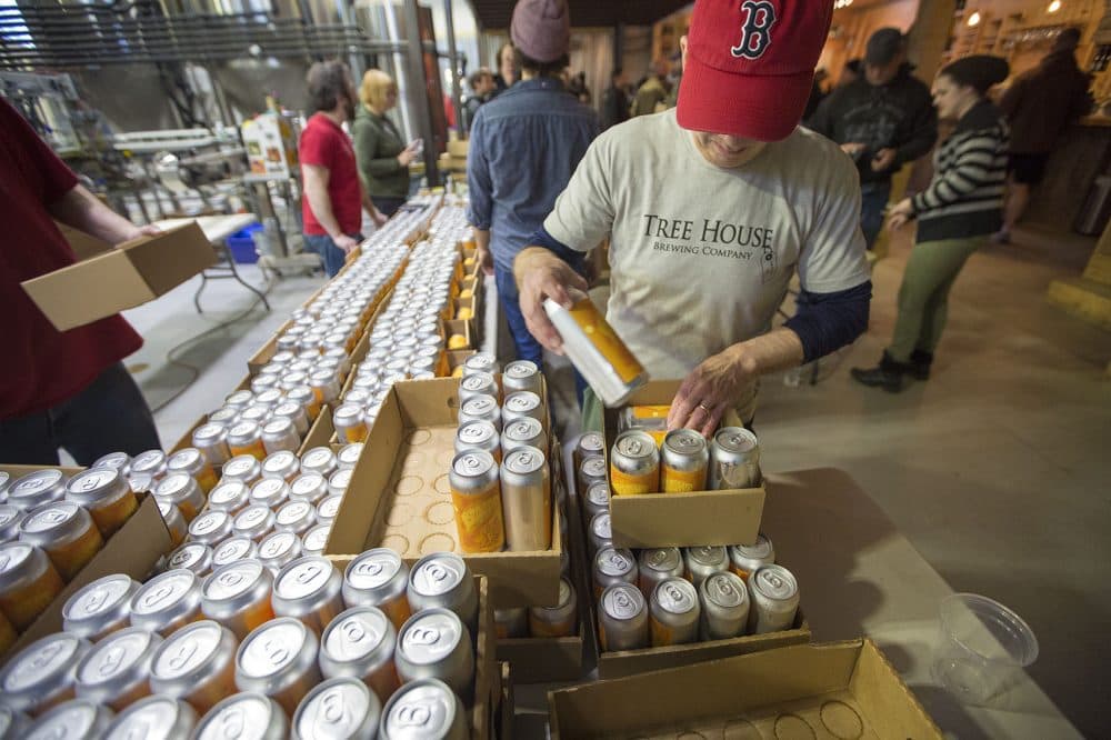 A worker at Tree House Brewing Co. in Monson assembles 10 packs for sale. Tree House customers can wait in line for hours to purchase the company's craft brews. (Jesse Costa/WBUR)