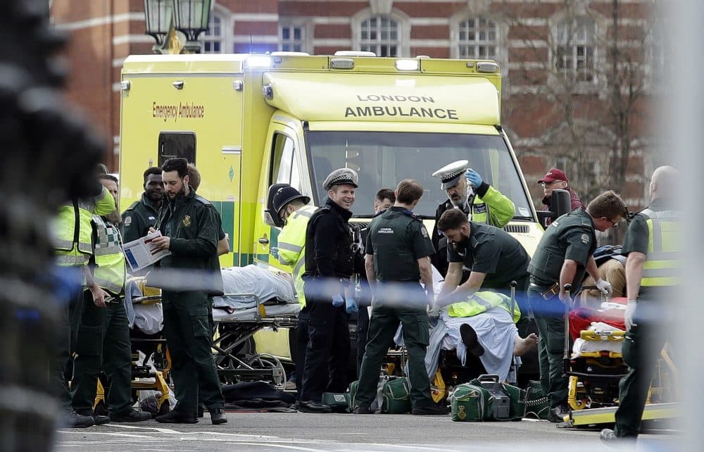 Emergency services staff provide medical attention close to the Houses of Parliament in London, Wednesday, March 22, 2017. London police say they are treating a gun and knife incident at Britain's Parliament &quot;as a terrorist incident until we know otherwise.&quot; The Metropolitan Police says in a statement that the incident is ongoing. Officials say a man with a knife attacked a police officer at Parliament and was shot by officers. Nearby, witnesses say a vehicle struck several people on the Westminster Bridge. (Matt Dunham/AP)