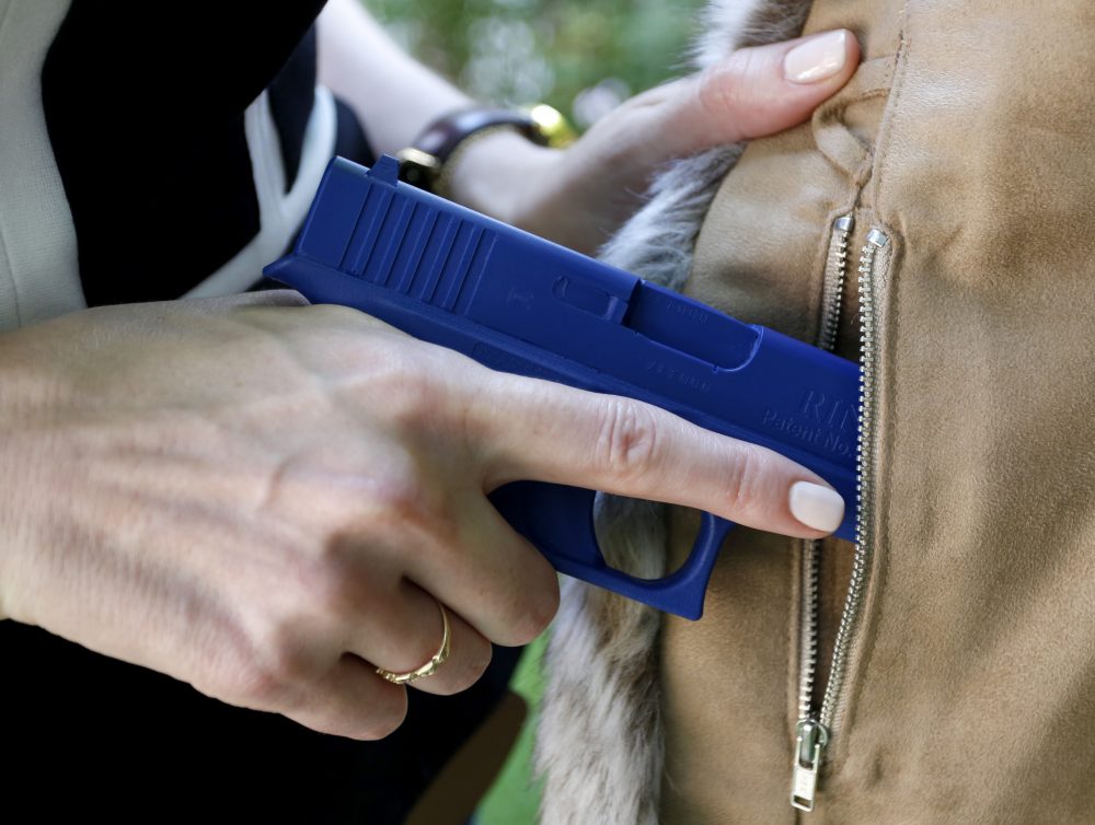 In this Aug. 29, 2016 photo, Marilyn Smolenski uses a mock gun to demonstrate how to pull a handgun out of the concealed carry clothing she designs at her home in Park Ridge, Ill. (Tae-Gyun Kim/AP)