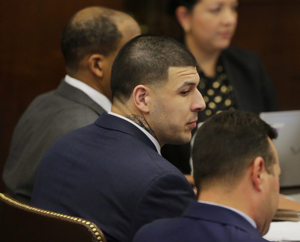 Former New England Patriots tight end Aaron Hernandez sits with his attorneys Jose Baez, right, and Ronald Sullivan, left, at the opening of the fist day of his double murder trial at Suffolk Superior Court on Wednesday in Boston. (Stephan Savoia/AP)