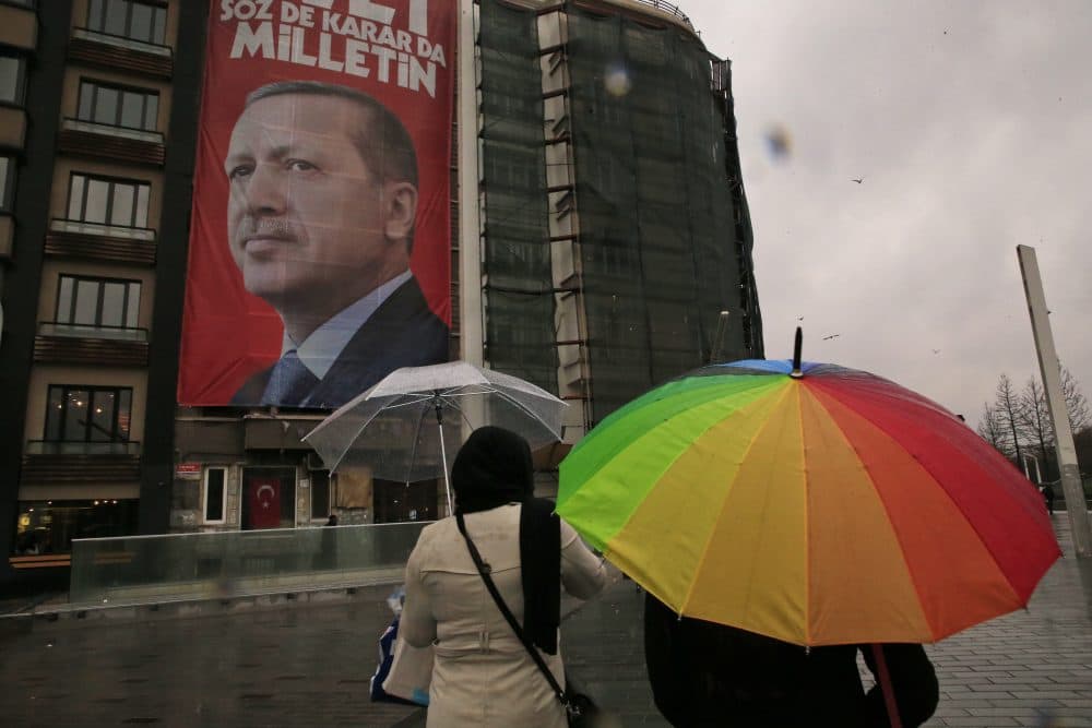 By mentioning Srebrenica, writes Susan E. Reed, President Erdogan undermines his own proposal for a safe zone along the Turkey-Syrian border. Pictured: People walk in central Istanbul's Taksim Square, backdropped by a poster of Turkish President Recep Tayyip Erdogan, Tuesday, March 14, 2017. Turkish President Recep Tayyip Erdogan on Tuesday directed fresh verbal attacks at the Netherlands amid their growing diplomatic spat, holding the country responsible for Europe's worst mass killing since World War II. In a televised speech, Erdogan referred to the massacre of some 8,000 Muslim men and boys in Srebrenica, eastern Bosnia, in 1995. (Lefteris Pitarakis/AP)