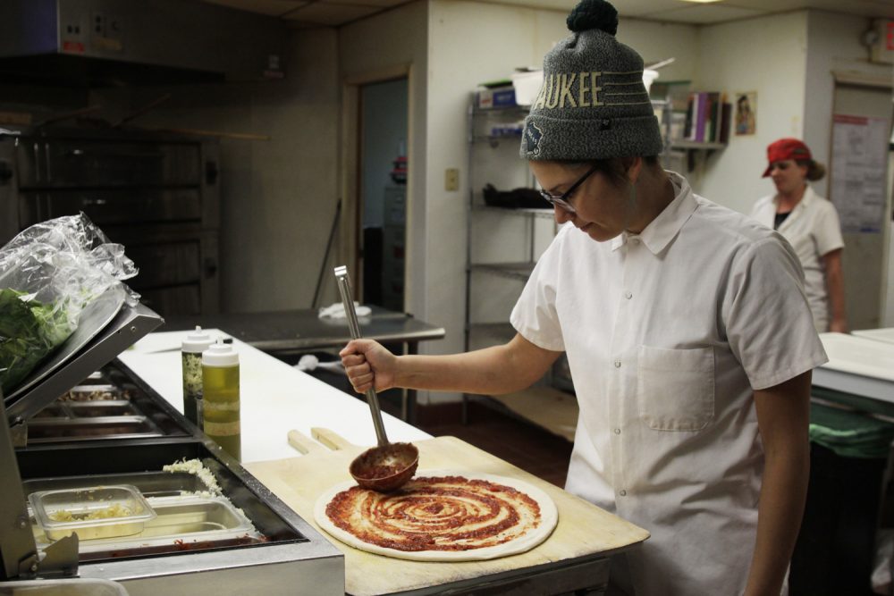 In this Jan. 9, 2017, photo, Andrea Ledesma spreads sauce on pizza dough at Classic Slice restaurant in Milwaukee. (Carrie Antlfinger/AP)