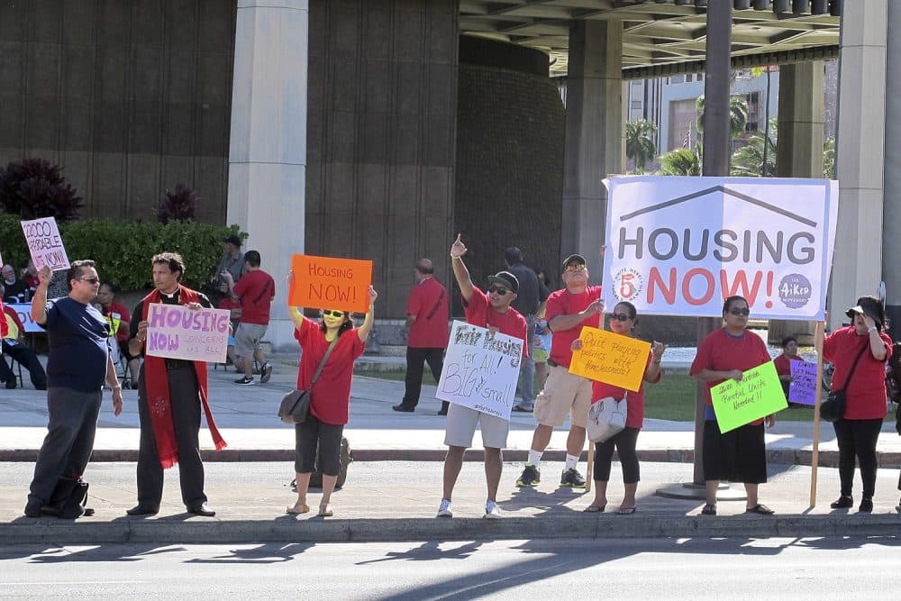 In this April 21, 2016 photo, affordable housing and homeless advocates rally outside the state capitol in Honolulu. Hawaii. (Cathy Bussewitz/AP)