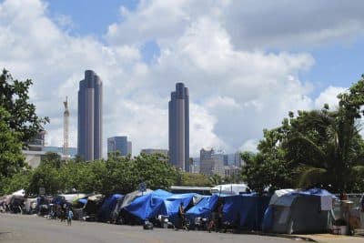 People camp out on a sidewalk in the Kakaako neighborhood of Honolulu. A Hawaii lawmaker wants to classify homelessness as a medical condition so that people could use Medicaid money for rent payments. (Audrey McAvoy/AP)