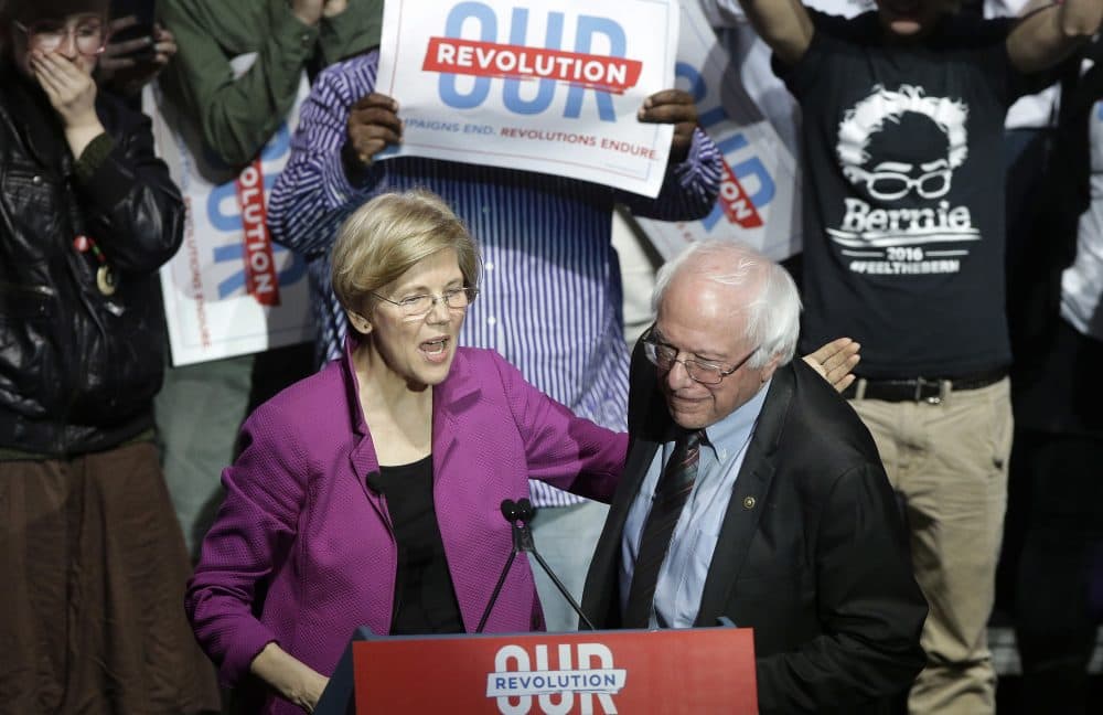 Sens. Elizabeth Warren and Bernie Sanders greet one another on stage at the Friday night rally. (Steven Senne/AP)