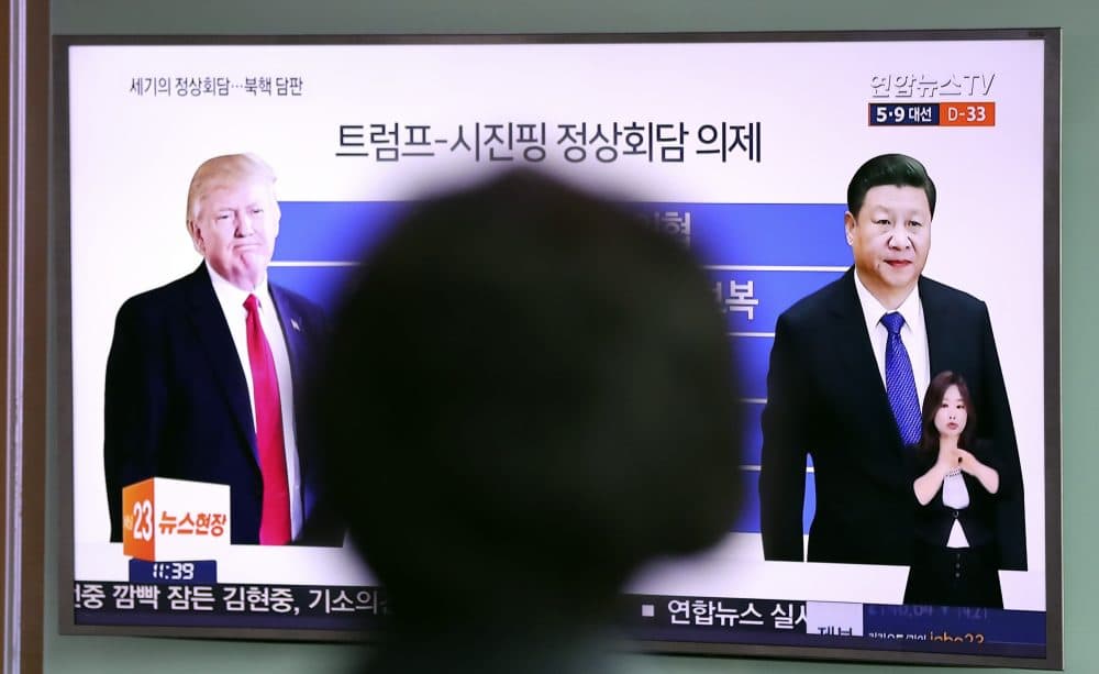 A woman watches a TV news program reporting about the first summit between U.S. President Donald Trump, left, and Chinese President Xi Jinping, at Seoul Train Station in Seoul, South Korea, Thursday, April 6, 2017. (Lee Jin-man/AP)