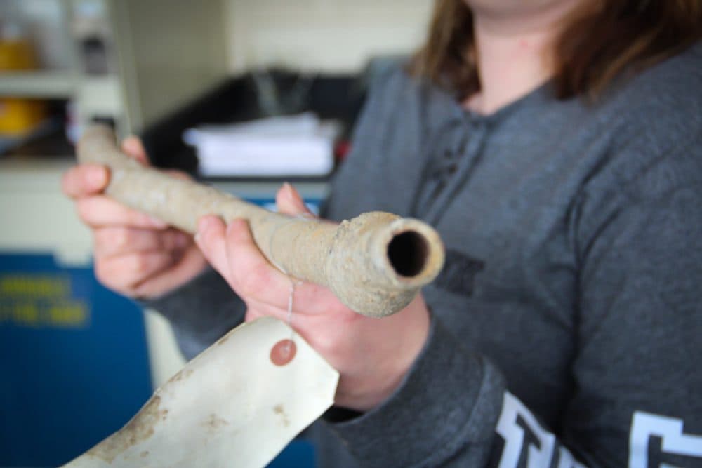 Gina Cyprych, acting head of water quality for the Pittsburgh Water & Sewer Authority holds up an old lead drinking water pipe. (Reid Frazier/Allegheny Front)
