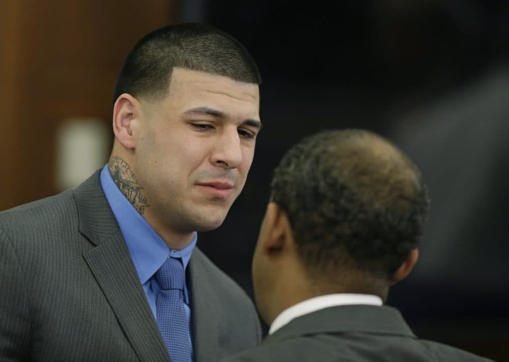 Former New England Patriots tight end Aaron Hernandez cries as he turns to defense attorney Ronald Sullivan reacting to his double murder acquittal at Suffolk Superior Court Friday. (Stephan Savoia/AP Pool)