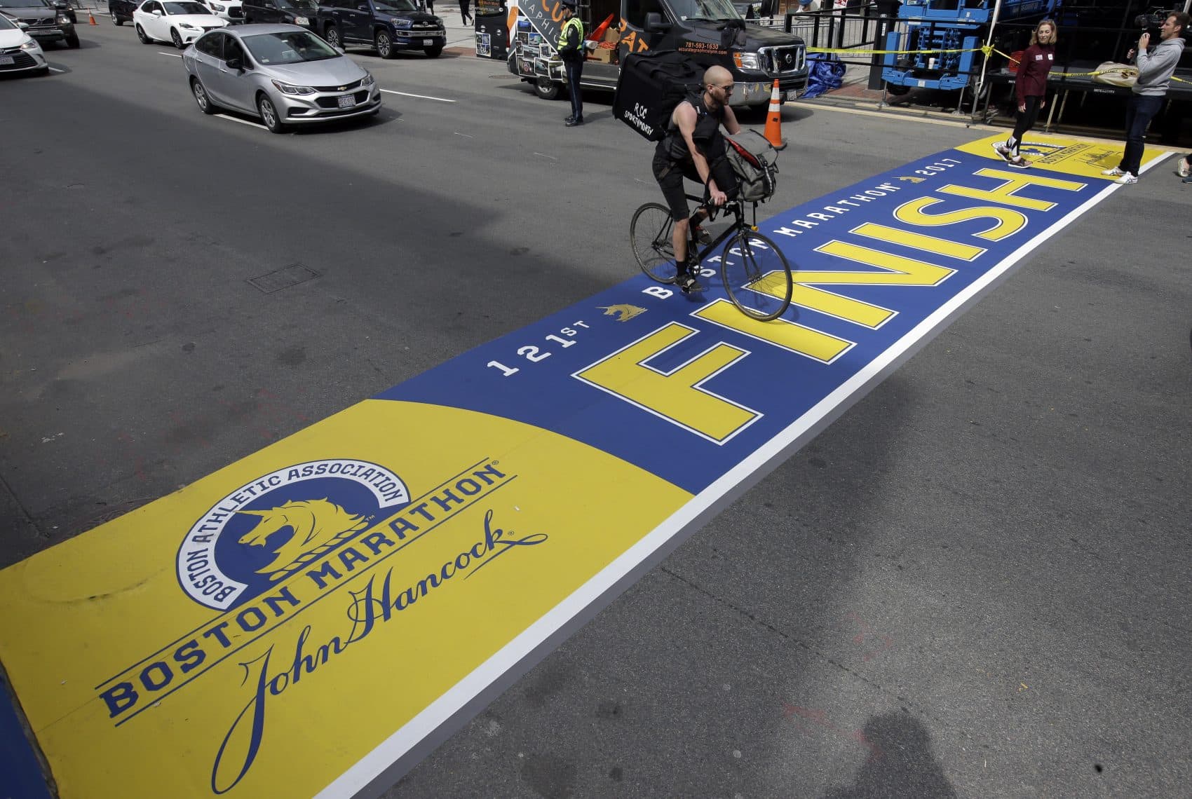 A cyclist rides over the newly applied Boston Marathon finish line on Boylston St., Thursday, April 13, 2017, in Boston. (Steven Senne/AP)
