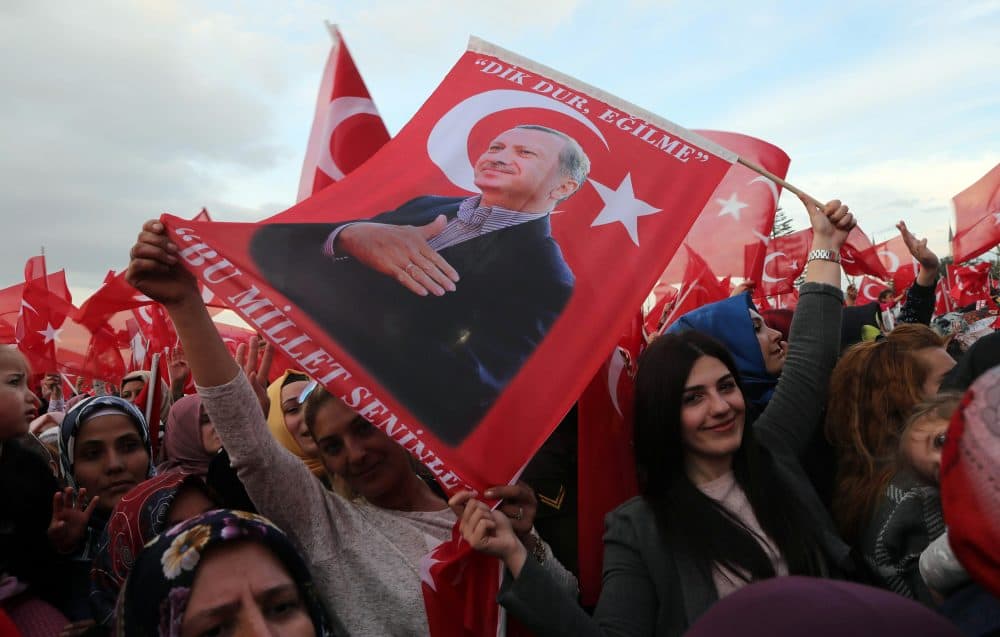 Supporters of the &quot;yes&quot; vote wave Turkish National flags and flags depicting Turkish president Recep Tayyip Erdogan as they cheer during his speech at the Presidential Palace in Ankara, on April 17, 2017, following the results in a nationwide referendum. (Adem Altan/AFP/Getty Images)