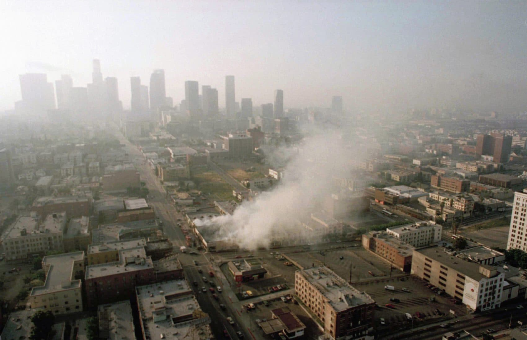 Smoke rises from a shopping center burned by rioters early Thursday morning on April 30, 1992, as the Los Angeles skyline is partially obscured by smoke. (Paul Sakuma/AP)