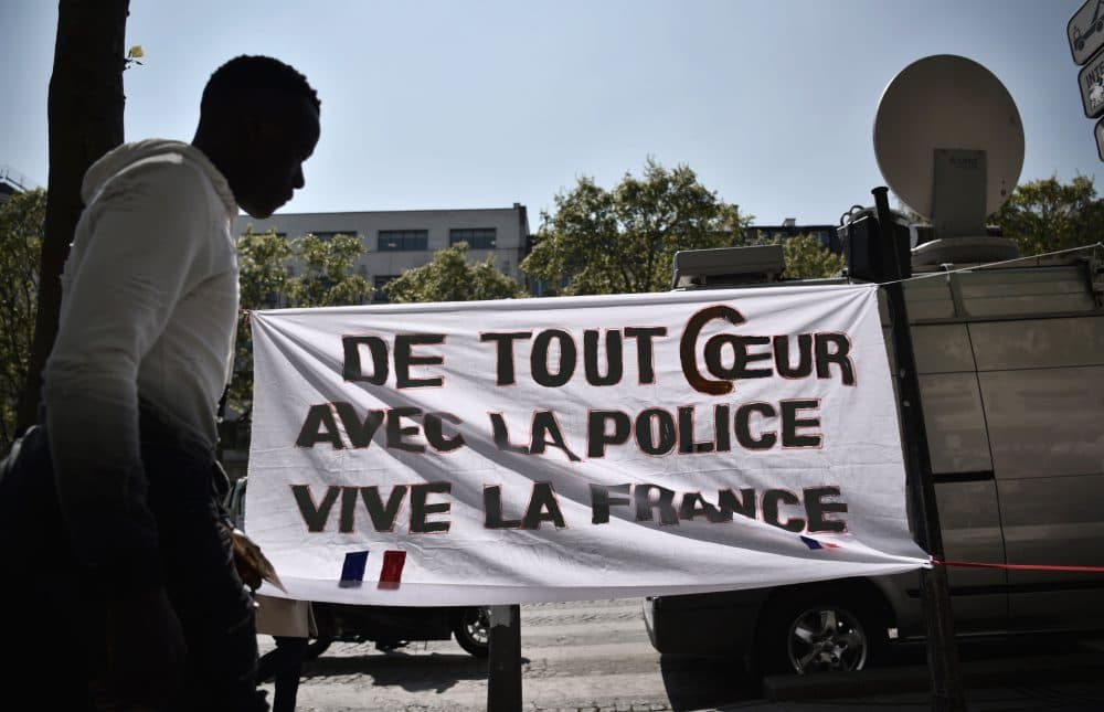 A man walks by a poster with an inscription which translates as &quot;With all my heart with the police, Long live France&quot; on the Champs Elysees in Paris on April 21, 2017, a day after a gunman opened fire on police on the avenue, killing a policeman and wounding two others in an attack claimed by the Islamic State group just days before the first round of the presidential election. (Philippe Lopez/AFP/Getty Images)