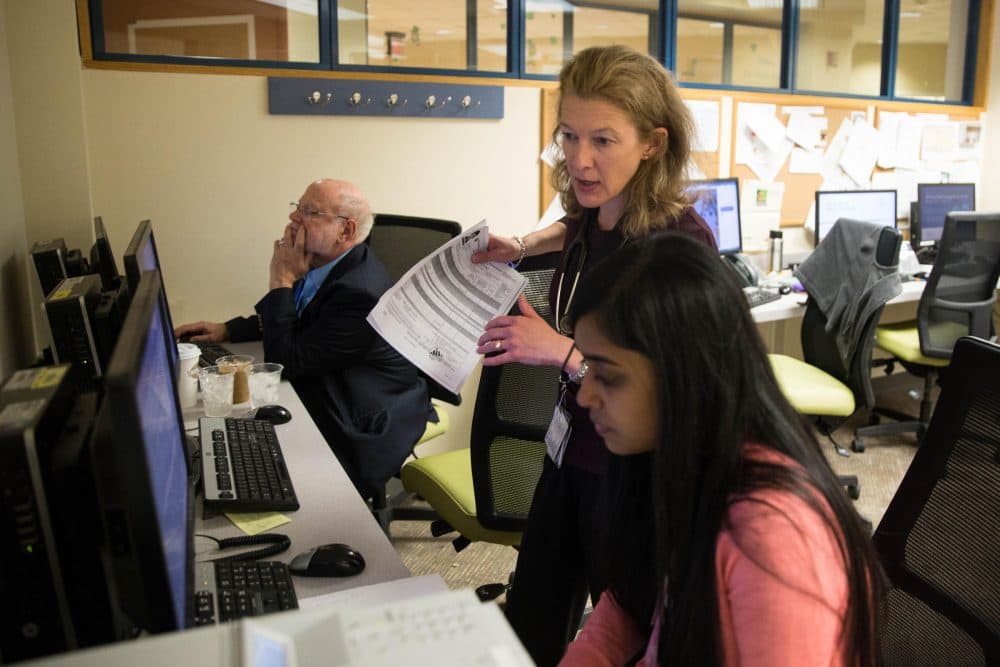 Dr. Camille Brown (standing), the director of Yale's pediatric refugee clinic, works with Dr. Soma Gauthami (right). (Ryan Caron King/WNPR)