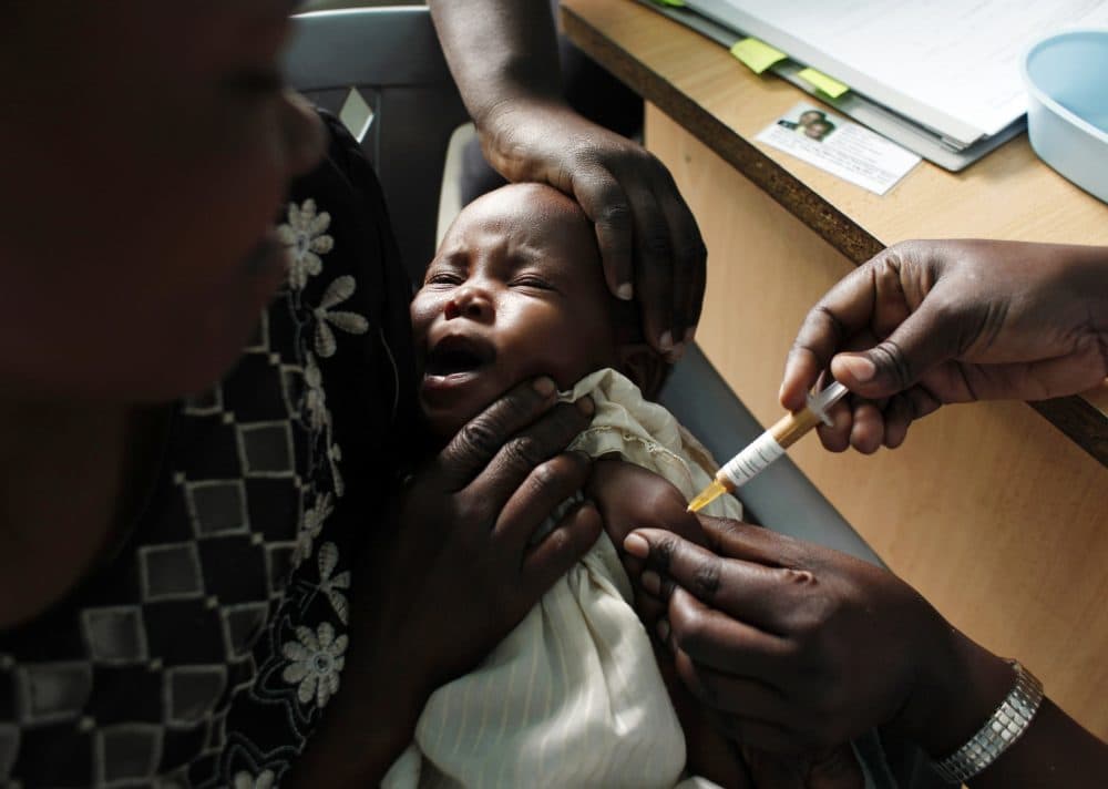In this Oct. 30, 2009, file photo, a mother holds her baby receiving a new malaria vaccine as part of a trial at the Walter Reed Project Research Center in Kombewa in Western Kenya. The World Health Organization says three African countries have been chosen to test the world's first malaria vaccine. (Karel Prinsloo/AP)