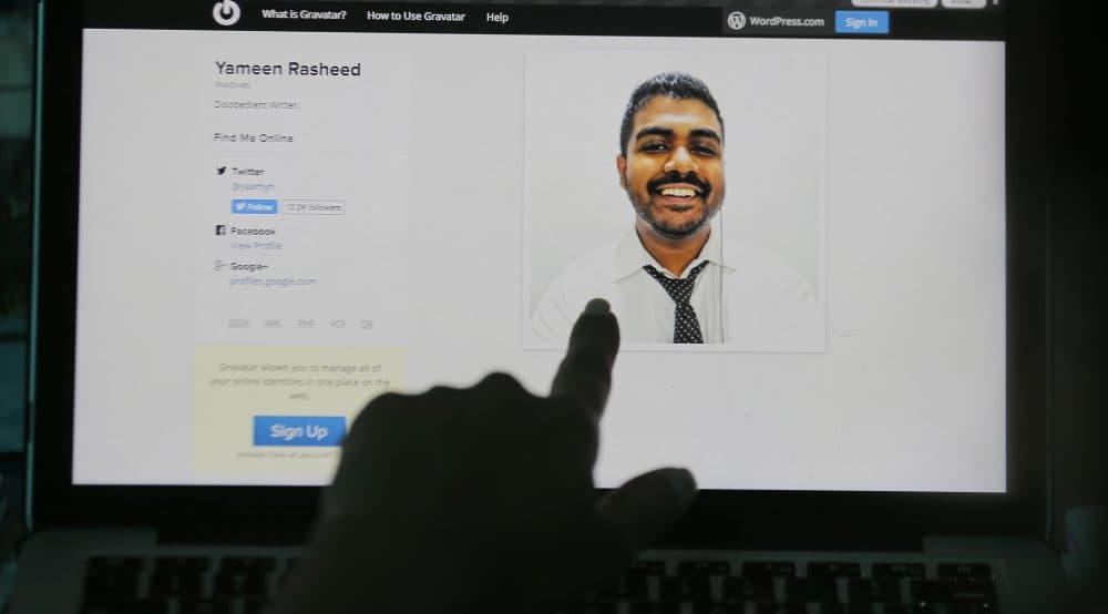 A Sri Lankan woman points to a portrait of Maldivian blogger Yameen Rasheed on his blog &quot;The Daily Panic&quot; in Colombo, Sri Lanka, Sunday, April 23, 2017. Police in the Maldives said in a statement that Rasheed was found Sunday morning with multiple stab wounds in a house in the capital, Male. He died at a hospital. (Eranga Jayawardena/AP)