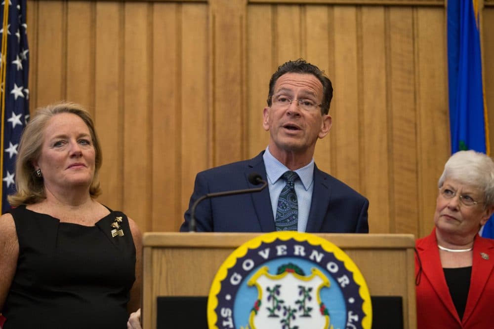 Connecticut Gov. Dannel Malloy, joined by his wife, Cathy Malloy, left, and Lt. Gov. Nancy Wyman, announced at a press conference Thursday that he would not seek a third term. (Ryan Caron King/WNPR)