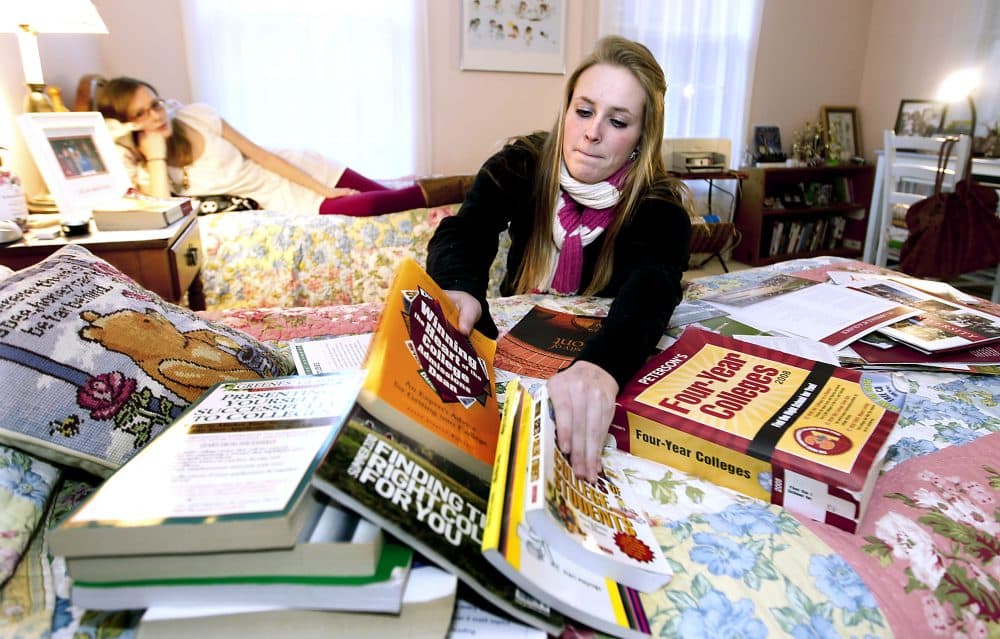 In this Thursday, Nov. 11, 2010 photo, Kim Pollock, 17, facing center, goes through college materials, as her sister Lindsay, 15, back left, watches, in her bedroom in Bedford, N.H.  (AP Photo/Cheryl Senter)