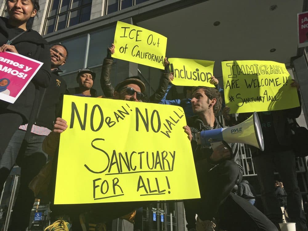 The president's tactics remind C. Nicholas Cuneo of those of Robert Mugabe, Zimbabwe's brutal dictator. Pictured: Protesters hold up signs outside a courthouse where a federal judge heard arguments in the first lawsuit challenging President Donald Trump's executive order to withhold funding from communities that limit cooperation with immigration authorities Friday, April 14, 2017, in San Francisco. U.S. District Court Judge William Orrick temporarily blocked the Trump administration from cutting off funds to any of the nation's so-called sanctuary cities. (Haven Daley/AP)