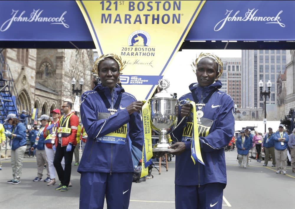 Edna Kiplagat, left, and Geoffrey Kirui, both of Kenya, hold a trophy together after their victories in the 121st Boston Marathon. (Elise Amendola/AP)