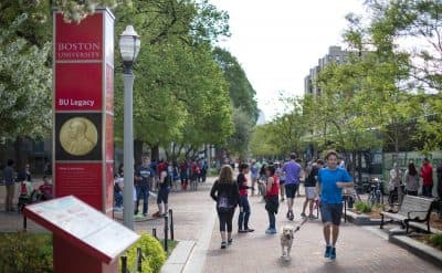 Pictured here: Students walk by a Boston University sign on Commonwealth Ave. (Robin Lubbock/WBUR)