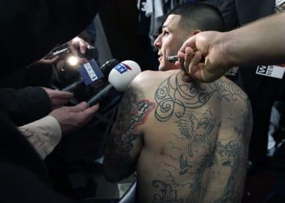It will be a shame if the story of Aaron Hernandez’s death becomes merely an investigation of the circumstances of the event, writes Bill Littlefield. Pictured: New England Patriots tight end Aaron Hernandez talks to reporters at his locker after NFL football practice in Foxborough, Mass., Friday, Jan. 27, 2012. (Elise Amendola/AP)