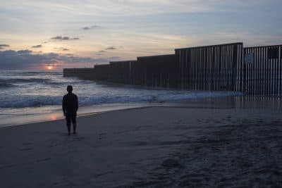 Someone needs to tell the President Trump and Congress a boat can go around a wall, a tunnel can go under a wall and a plane can go over a wall, writes comedian Jimmy Tingle. Pictured: A man stands on the shore of the Pacific Ocean by the US-Mexico border fence that separates Tijuana, Mexico, from San Diego, Calif. (Rodrigo Abd/AP)