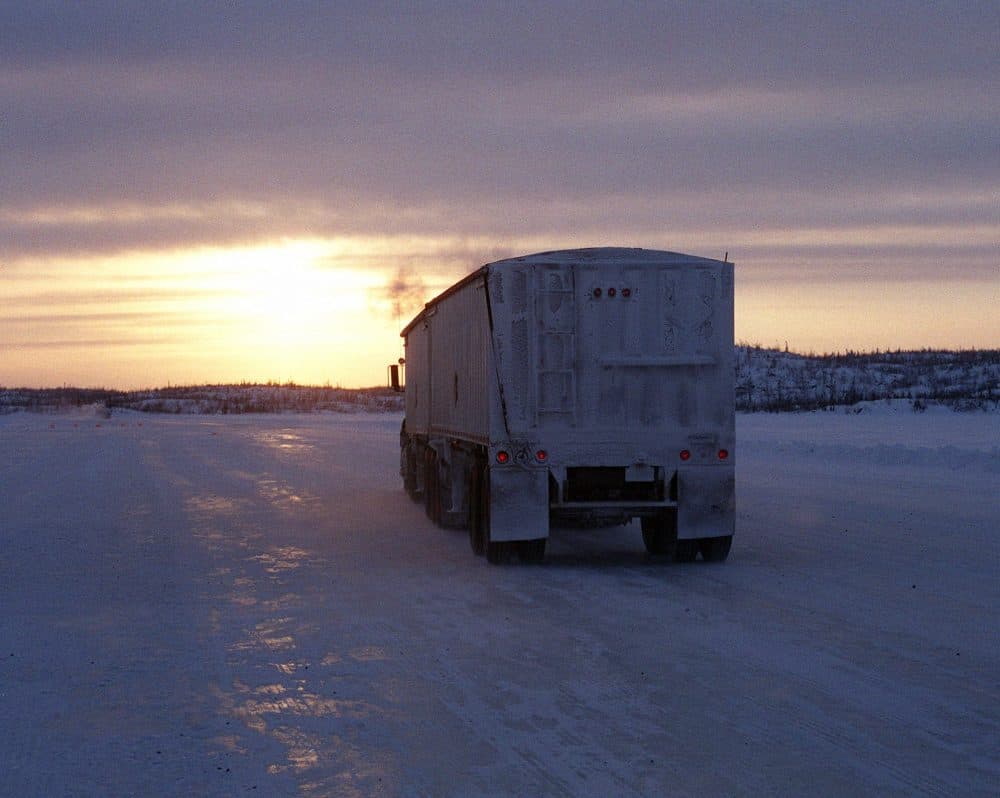 A truck heads toward the sunset on the Lupin winter road in Canada's Northwest Territories in 2001. (Bob Green/AP)