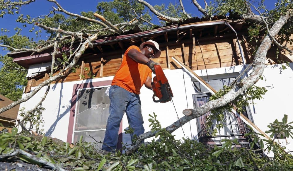 Pastor Michael Williams cuts branches from a wind-blown tree on Monday, May 1, 2017, that fell on a family member's home in Durant, Miss. (Rogelio V. Solis/AP)