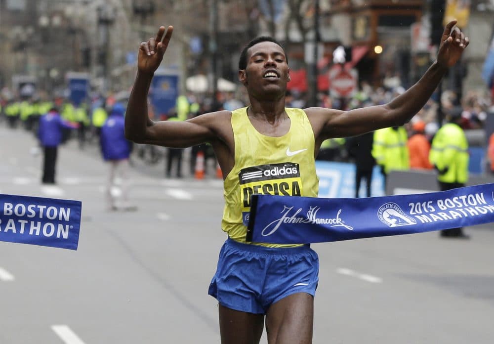 Ethiopian runner Lelisa Desisa crosses the finish line to win the men's division of the 2015 Boston Marathon. Desisa and two other elite runners will now try to run the world's first sub-two-hour marathon. (Elise Amendola/AP)