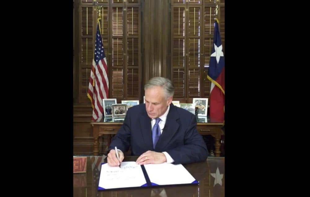 In this Sunday, May 7, 2017 frame from video posted by the Office of the Governor, Republican Gov. Greg Abbott signs a so-called &quot;sanctuary cities&quot; ban in Austin Texas. The ban lets police ask during routine stops whether someone is in the U.S. legally and threatens sheriffs with jail if they don't cooperate with federal immigration agents. (Office of Gov. Abbott via AP)