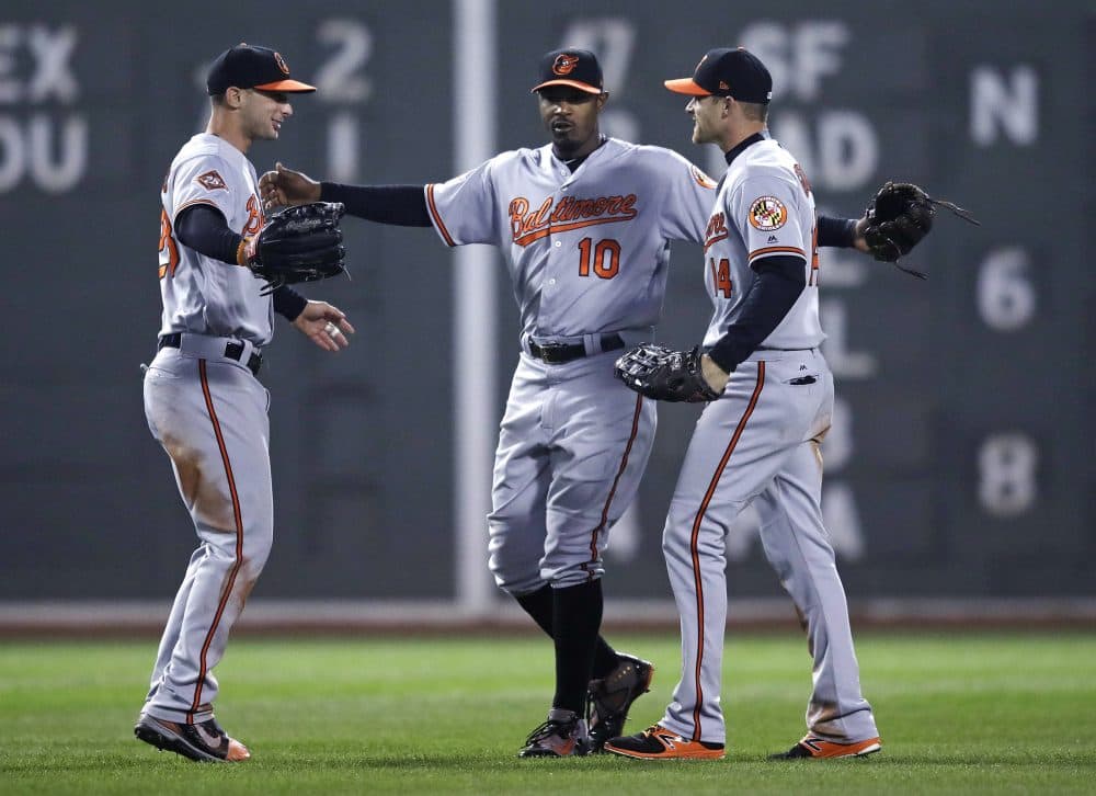 Baltimore Orioles center fielder Adam Jones, center, with teammates during a game at Fenway Park in Boston on Monday. (Charles Krupa/AP)
