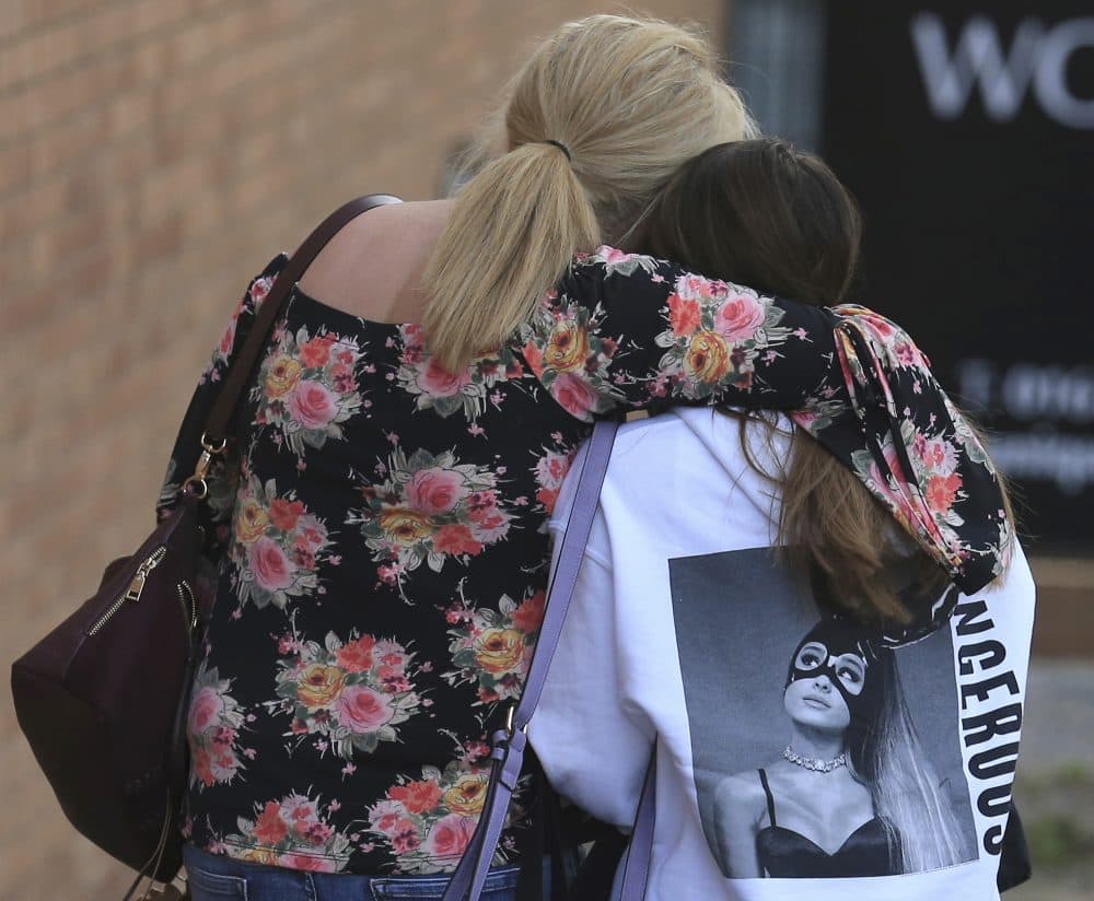 A fan is comforted as she leaves the Park Inn hotel in central Manchester, England on Tuesday. More than 20 people were killed in an explosion following a Ariana Grande concert at the Manchester Arena late Monday evening. (Rui Vieira/AP)