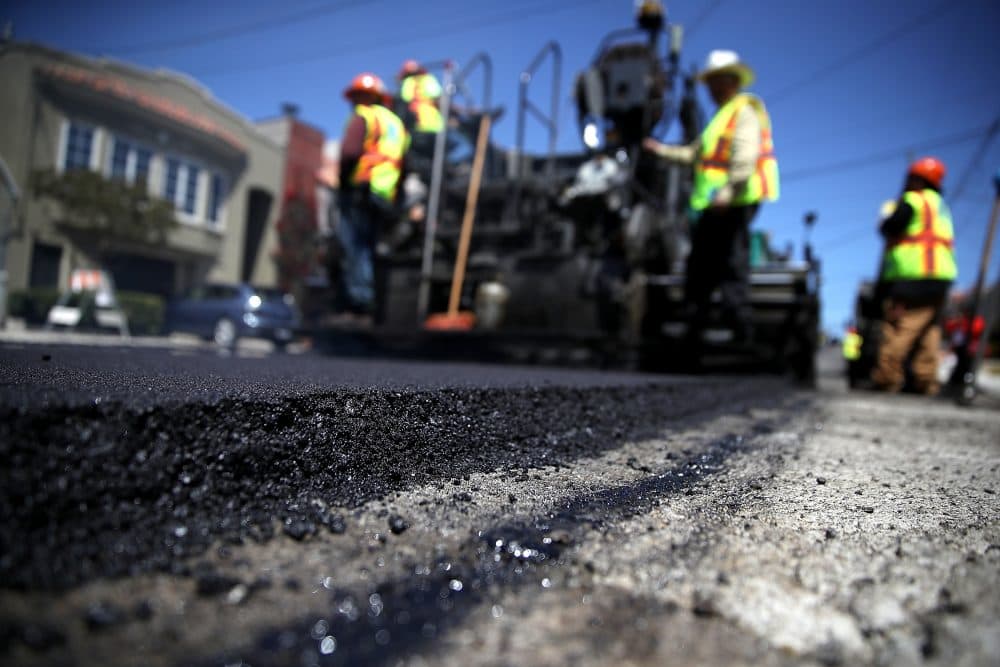 City workers lay asphalt in San Francisco in May. (Justin Sullivan/Getty Images)