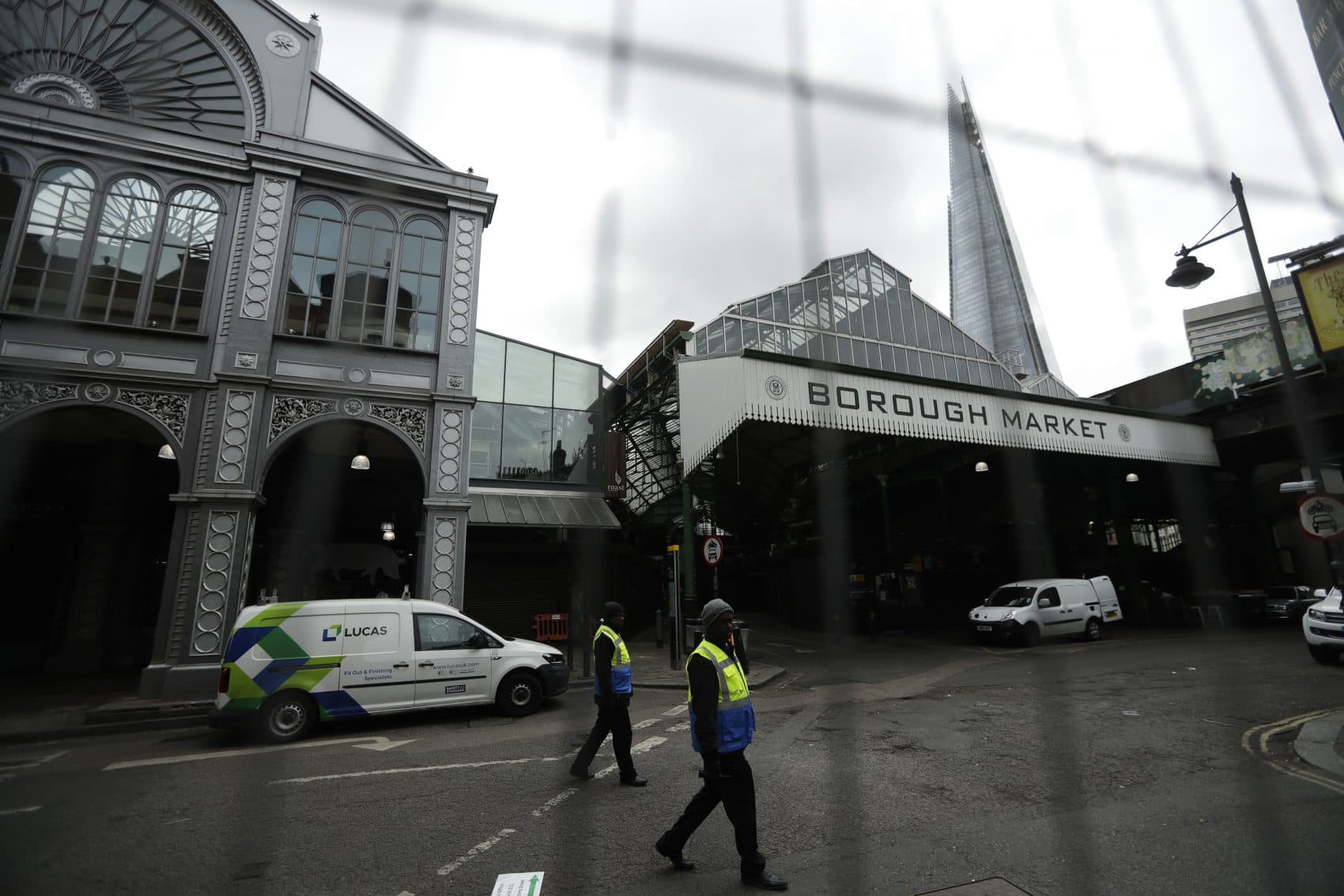 Security marshals are seen through a fence walking beside Borough market, in London, which remains closed to the public after the attack that took place there, Monday, June 12, 2017. (Matt Dunham/AP)