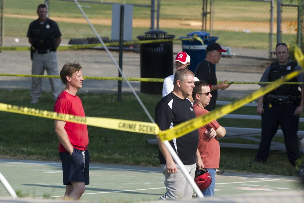 Members of the Republican Congressional softball team stand behind police tape in Alexandria, Va., Wednesday, June 14, 2017, after a multiple shooting involving House Majority Whip Steve Scalise of La. during a congressional baseball practice. (Cliff Owen/AP)