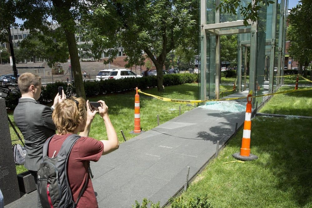 People take photos of the damage to the New England Holocaust Memorial in Boston Wednesday morning. A 21-year-old Boston man is facing charges he vandalized the memorial. (Robin Lubbock/WBUR)