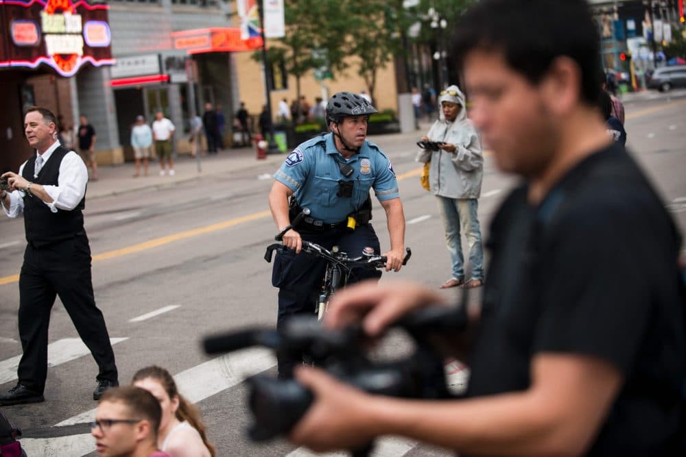 A police officer bikes through a protest on July 17, 2017 in Minneapolis, Minn. Demonstrations have taken place each day since a jury acquitted police officer Jeronimo Yanez in the shooting death of Philando Castile. (Stephen Maturen/AFP/Getty Images)