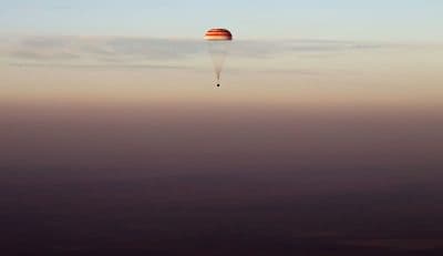 Perhaps aliens or robots would see enough potential in humanity to take us under their wing, writes Joelle Renstrom. And no travel ban or wall would stop them. Pictured: The Soyuz TMA-19M capsule carrying NASA's Jeff Williams, and two Russian cosmonauts descends beneath a parachute over Kazakhstan, in Sept., 2016 after a six-month mission aboard the International Space Station. (Maxim Shipenkov/AP)