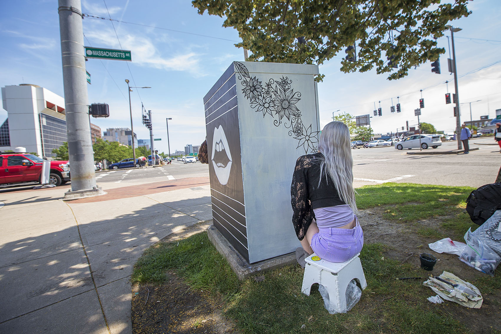Artist Kitty Zen draws a design on an electrical box at the corner of Massachusetts Avenue and Melnea Cass Boulevard. (Jesse Costa/WBUR)