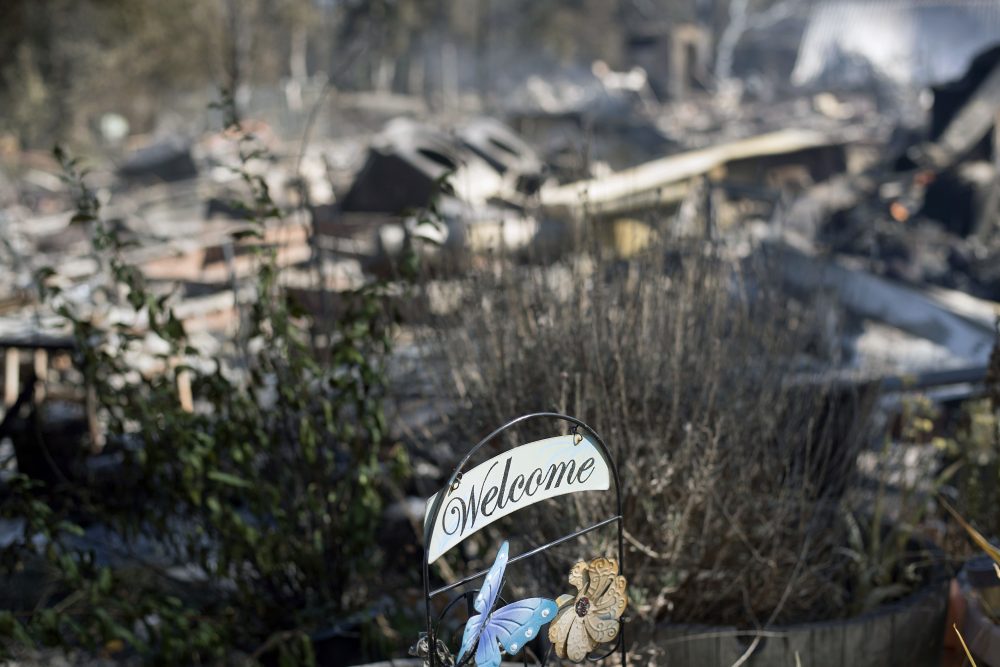 A welcome sign rests in front of residence leveled by a wildfire Sunday, July 9, 2017, near Oroville, Calif. Wildfires barreled across the baking landscape of the western U.S. and Canada, destroying a smattering of homes and forcing thousands to flee. (Noah Berger/AP)