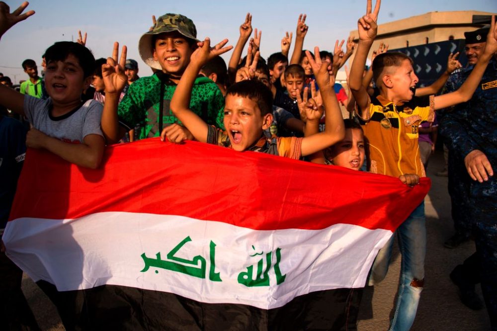 Children holding Iraq's national flag react as Iraqi forces celebrate in the Old City of Mosul on July 9, 2017 after the government's announcement of the &quot;liberation&quot; of the embattled city. Iraq declared victory against the Islamic State group in Mosul on July 9 after a grueling months-long campaign, dealing the biggest defeat yet to the jihadist group. (Fadel Senna/AFP/Getty Images)