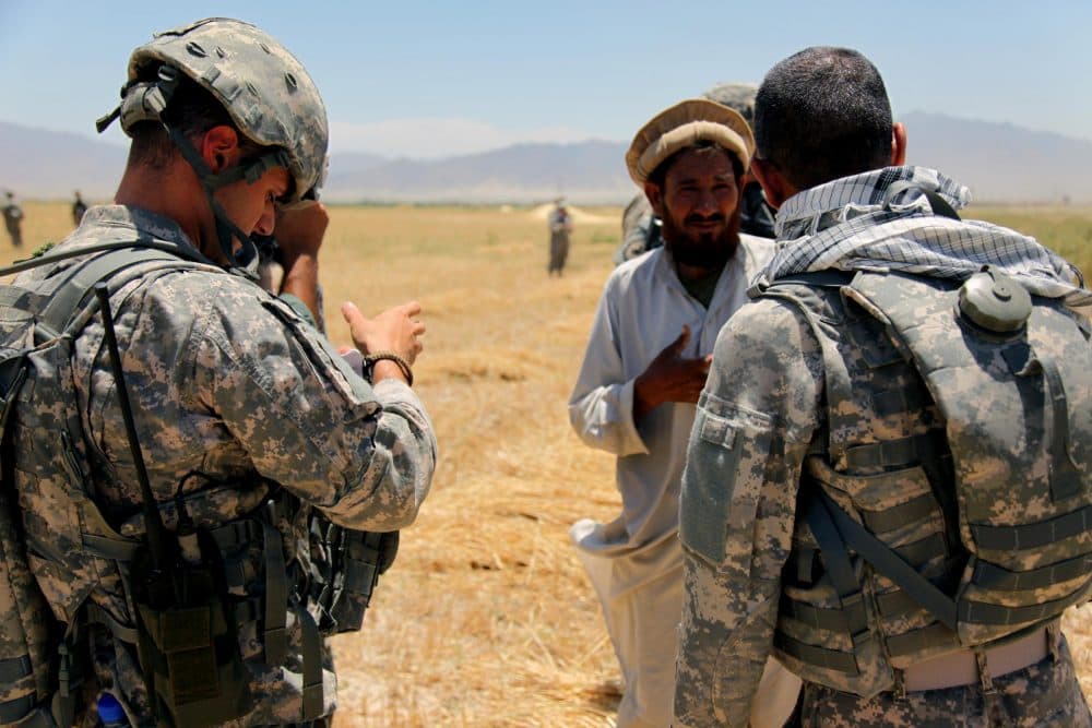 An Afghan interpreter (right) helps a U.S. soldier gather information from a local resident in this 2010 photo. (Corey Idleburg/U.S. Army)