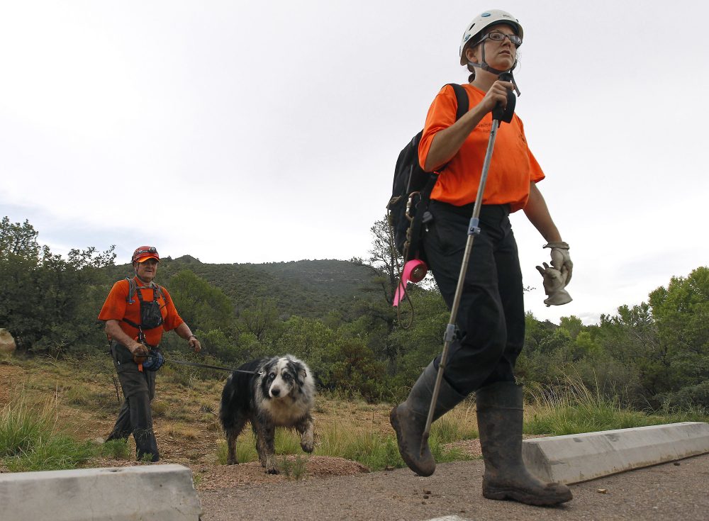 Members of the Tonto Rim Search and Rescue team exit a section of forest after searching along the banks of the East Verde River for victims of a flash flood, Sunday, July 16, 2017, in Payson, Ariz. Search and rescue crews, including 40 people on foot and others in a helicopter, have recovered bodies of children and adults, some as far as two miles down the river after Saturday's flash flooding poured over a popular swimming area inside the Tonto National Forest in central Arizona. (Ralph Freso/AP)