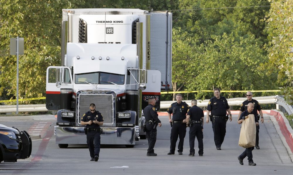 San Antonio police officers investigate the scene where nine people were found dead in a tractor-trailer loaded with at least 30 others outside a Wal-Mart store in stifling summer heat in what police are calling a horrific human trafficking case, Sunday, July 23, 2017, in San Antonio. (Eric Gay/AP)