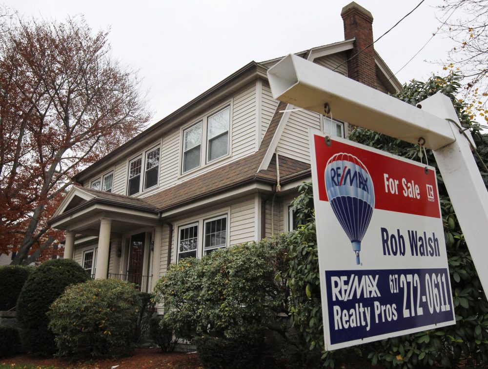A rare sight these days: In this 2011 file photo, a for sale sign hangs in front of a home in Milton. (Steven Senne/AP)